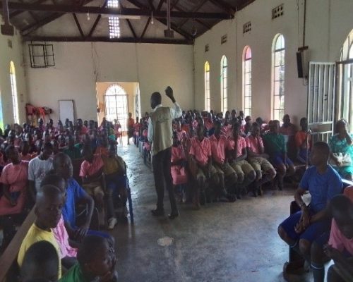 PHIC staff conducting IEC session on 11th June 2024 At Kavumba church of Uganda primary school